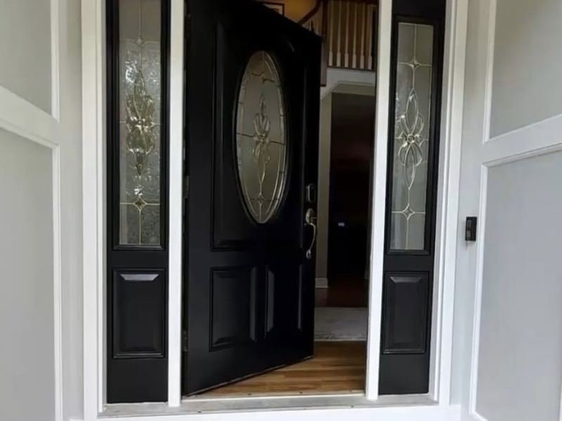 Black front door with decorative glass and white trim