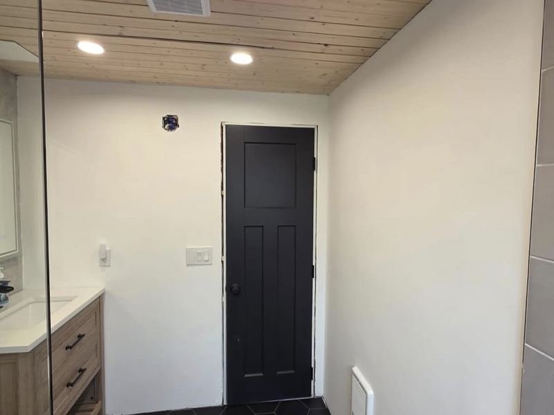 Bathroom with black hex tile and wood plank ceiling